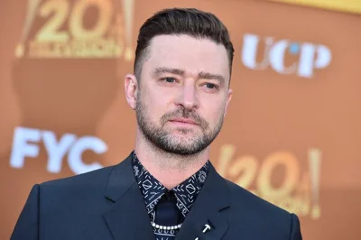 Justin Timberlake looks serious in a dark suit at a movie premiere.