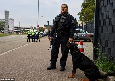 A German police officer stands guard next to a dog at a border with France on Monday