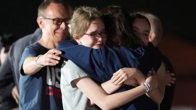 Журналістка Алсу Курмашева обіймає свого чоловіка та своїх донього після повернення додому, 2 серпня 2024 року