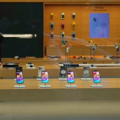 A selection of iPhones displayed on wood tables.