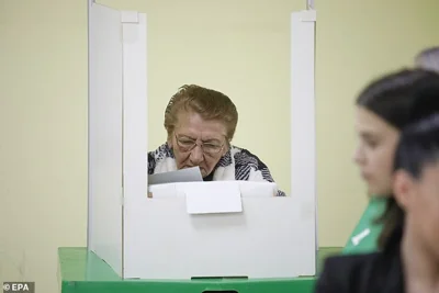 A Georgian woman casts her ballot during parliamentary elections, at a polling station in Tbilisi, Georgia, 26 October 2024