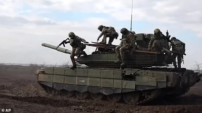 Russian servicemen jump off a T-90M Proryv tank during a combat training for assault units in an undisclosed location