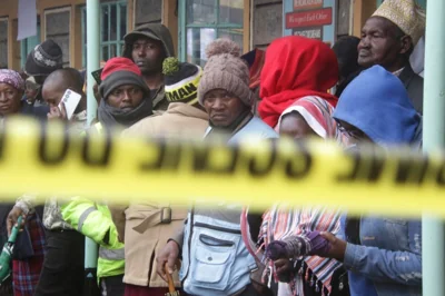 Distressed parents stand near a burnt-out dormitory, following a fire at the Hillside Endarasha Primary in Nyeri, Kenya