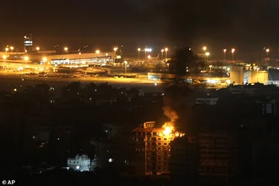 Flames and smoke rise from a building that was hit by an Israeli airstrike in Dahiyeh, as Rafik Hariri International airport is seen in the background, in Beirut, Lebanon, Friday, Oct. 4, 2024