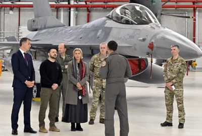 Volodymyr Zelenskiy standing with other people near a fighter jet