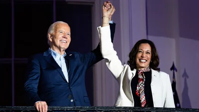 President Joe Biden and Vice President Kamala Harris hold hands on balcony