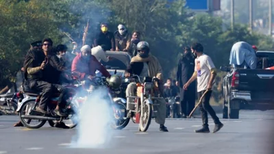 Supporters of imprisoned former Premier Imran Khan's Pakistan Tehreek-e-Insaf party move advance following police fire tear gas shell to disperse them during clashes, in Islamabad, Pakistan, Tuesday, Nov. 26, 2024.