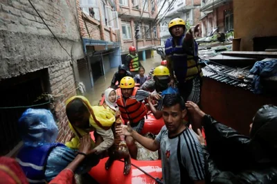 Security force members use an inflatable raft to bring residents to safety from a flooded area near the bank of the overflowing Bagmati River following heavy rains, in Kathmandu, Nepal September 28, 2024. REUTERS/Navesh Chitrakar