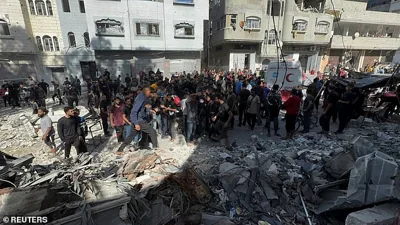 Palestinians inspect the site of an Israeli strike on a school sheltering displaced people, amid the ongoing Israel-Hamas conflict, in Gaza City, October 27, 2024