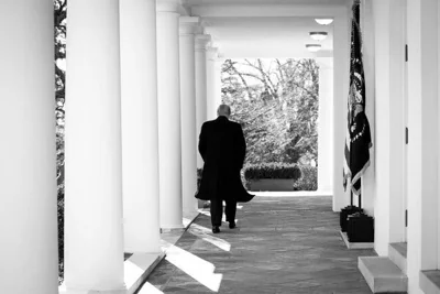 A photograph of Donald Trump walking the grounds of the White House.