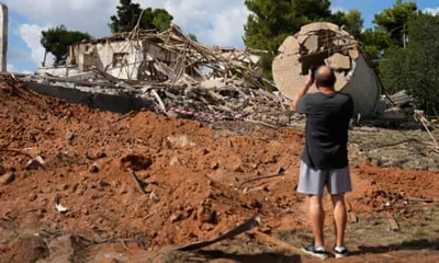 A man takes photos of a destroyed building that was hit in Iran’s missile attack in Hod Hasharon, Israel, 2 October.