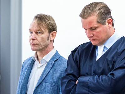 Brueckner standing next to his lawyer Friedrich Fuelscher at his trial on unrelated sexual assault charges