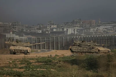 Israeli tanks stand near the Israel-Gaza border as seen from southern Israel Sunday, July 14, 2024. (AP Photo/Tsafrir Abayov)