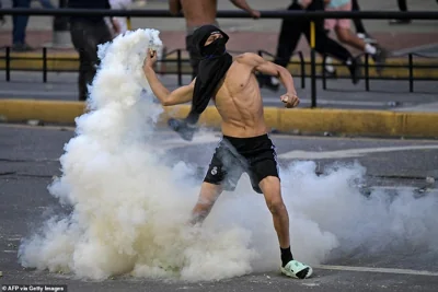 A demonstrator throws back to police a teargas can during a protest against Venezuelan President Nicolas Maduro's government in Caracas on July 29, 2024