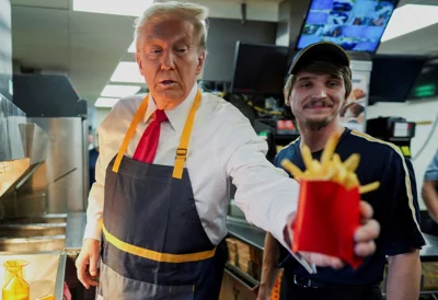 Donald Trump works behind the counter during a visit to McDonalds