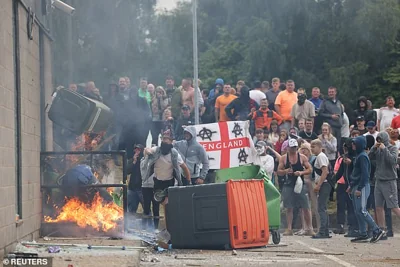 Violence escalates as protesters throw garbage bins on a fire outside a hotel in Rotherham