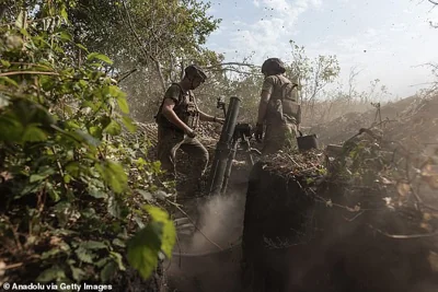 Ukrainian soldier in a mortar unit prepares to fire a missile