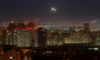 Explosions are seen in the sky over the city during a Russian drone strike in Kyiv.