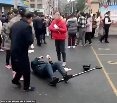 A person lies on the ground following a vehicle collision outside a primary school in Changde, Hunan province, China in this screengrab obtained from social media video released November 19, 2024