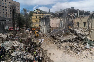 Firefighters hose down a destroyed children’s hospital.