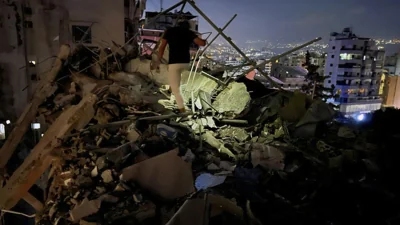 A man inspects a destroyed building that was hit by an Israeli airstrike in the southern suburbs of Beirut, Lebanon, Tuesday, July 30, 2024   (AP Photo/Hussein Malla)