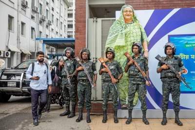 Military personnel stand in front of a portrait of Prime Minister Sheikh Hasina in Dhaka, Bangladesh, on July 30, 2024