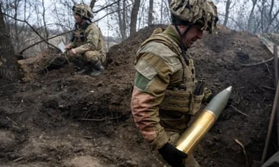 A Ukrainian soldier carrying a shell