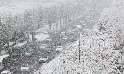 Cars move slowly on a snow-covered road in southern Seoul, South Korea, amid a heavy snow alert