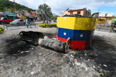 A destroyed statue of the late Venezuelan President Hugo Chavez lies next to its base in Valencia on Tuesday after Chavez's protege, Maduro, was named winner in Sunday's presidential election.