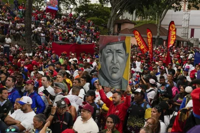 Government loyalists hold a poster of the late former President Hugo Chavez outside the presidential palace during a rally in support of President Nicolas Maduro's reelection.