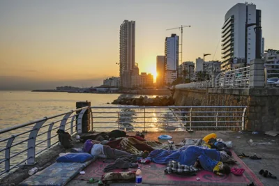 Families sleep on Beirut's corniche after fleeing the Israeli airstrikes in Beirut's southern suburbs on Sept. 30, 2024.