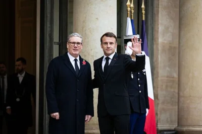 French President Emmanuel Macron (R) welcomes British Prime-...