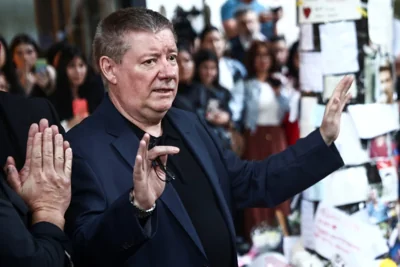 A distraught Geoff Payne, Liam Payne's dad, waves to fans outside the hotel in Argentina