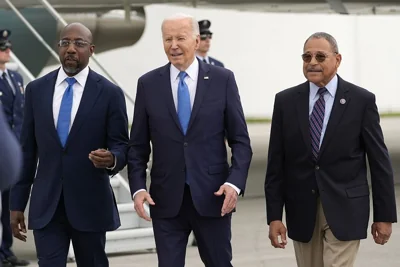 President Joe Biden walks with Senator Raphael Warnock and Representative Sanford Bishop, upon arriving at Hartsfield-Jackson Atlanta International Airport in Atlanta.
