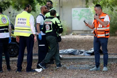 First responders work at the site of a stabbing attack that, Israeli police said, a Palestinian attacked killed a woman and wounded a few others in Holon, Israel Sunday, Aug. 4, 2024.(AP Photo/Tomer Appelbaum)