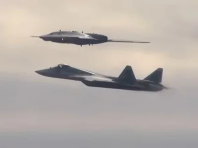 An earlier version of the Okhotnik combat drone (above) flies alongside an Su-57 jet