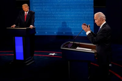 Donald Trump stares at Joe Biden as he speaks behind a podium at a 2020 presidential debate.