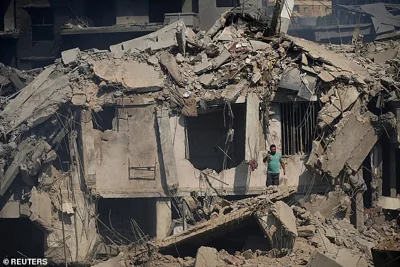 A civil defence member stands amid damage in the aftermath of what security sources said was an Israeli strike on a market in southern Lebanon