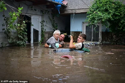 ROMANIA: Local residents rescue an elderly man from the rising flood waters in the village of Slobozia Conachi