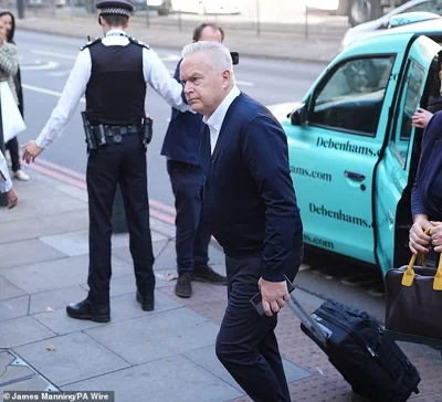 Former BBC news anchor Huw Edwards arrives at Westminster Magistrates' Court in London this morning with a wheelie suitcase