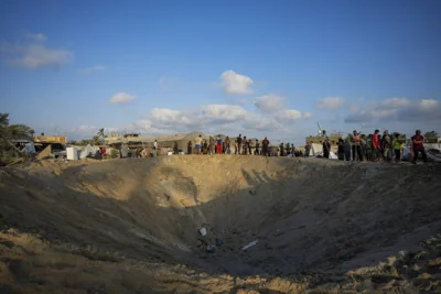 GROUND ZERO People look at a huge hole where part of a crowded tent camp housing displaced Palestinians was located following an Israeli airstrike on Al-Muwasi, city of Khan Younis, southern Gaza Strip, on Sept. 10, 2024. AP PHOTO