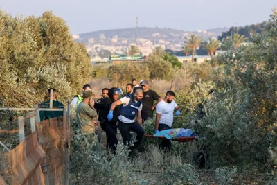 First responders carry the shrouded body of a woman who was killed when a rocket fired from Lebanon hit an area near Kiryat Ata in northern Israel's Haifa district on Oct. 31, 2024.