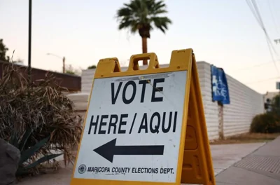 A Vote Here/Aqui sign is posted at a polling place at a church after the polls opened before sunrise, in Tempe, Ariz., Nov. 5. AFP-Yonhap