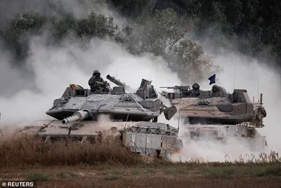 Israeli tanks manoeuvre near the border after entering Israel from Gaza on July 4