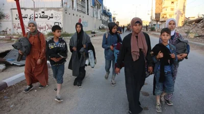 Displaced Palestinians, ordered by the Israeli army to leave the school in Beit Lahiya where they were sheltered, arrive in Gaza City