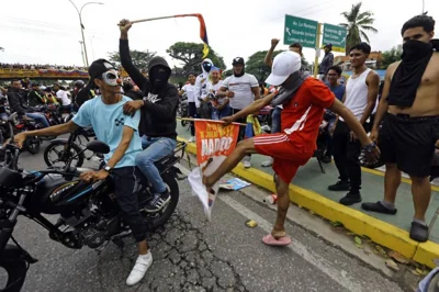MAD AT MADURO A demonstrator kicks a campaign poster of Venezuela’s President Nicolas Maduro during a protest in the city of Valencia, northern Carabobo state, on July 29, 2024. AFP PHOTO