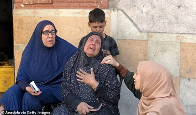 Relatives of the Palestinians who died as a result of Israeli attacks on the 5-storey building belonging to the Abu Nasr family mourn as Palestinians and Civil Defense Teams conduct search and rescue operations in the rubble of buildings in Beit Lahia