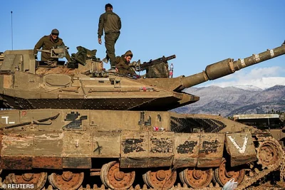 Israeli soldiers work on a tank, amid cross-border hostilities between Hezbollah and Israel, by Israel's border with Lebanon in northern Israel, November 26, 2024