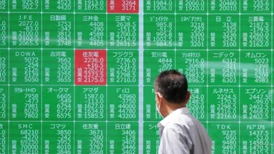 A man looks at an electronic quotation board displaying stock prices of Nikkei 225 on the Tokyo Stock Exchange in Tokyo.(AFP)
