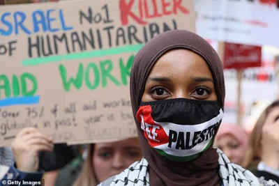 A protester wears a "Free Palestine" face mask as people gather for a 'Stop The War Coalition' demonstration against Israeli strikes on Gaza and Lebanon